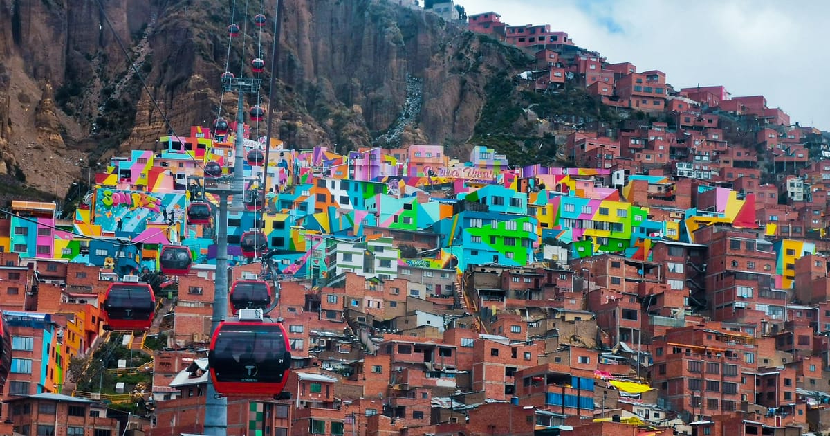 Casas de colores del barrio Chualluma, en La Paz, con cabinas del teleférico al frente.