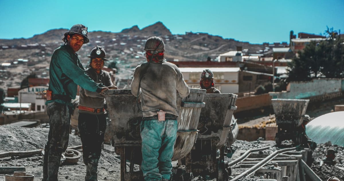 Mineros junto a carros de mineral a la salida de una mina del Cerro Rico de Potosí.