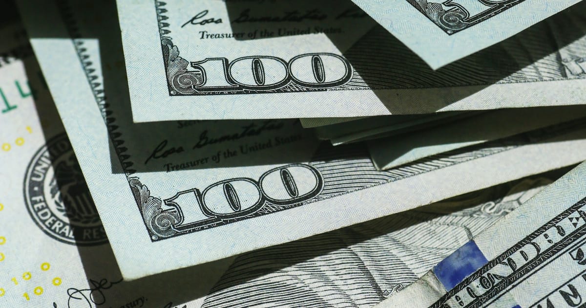 Billetes de cien dólares estadounidenses apilados unos sobre otros.